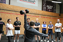 professeur de sport montrant un exercice de sport avec un haltère, à ses élèves