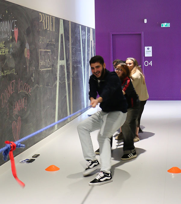 Etudiants souriants et qui tirent sur une corde