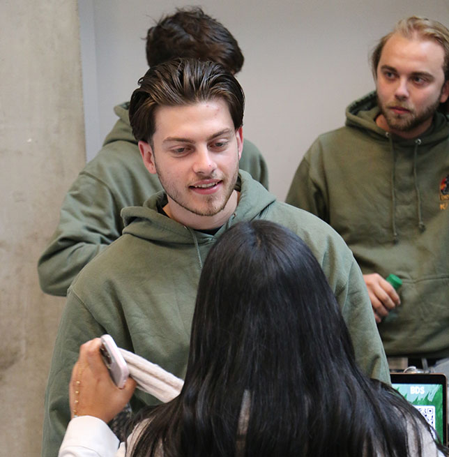 Un étudiant qui fait partie de l'association le bureau des étudiants parle avec une étudiante.