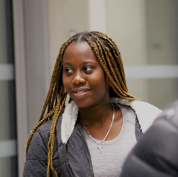 Jeune femme qui sourie et qui regarde à gauche.