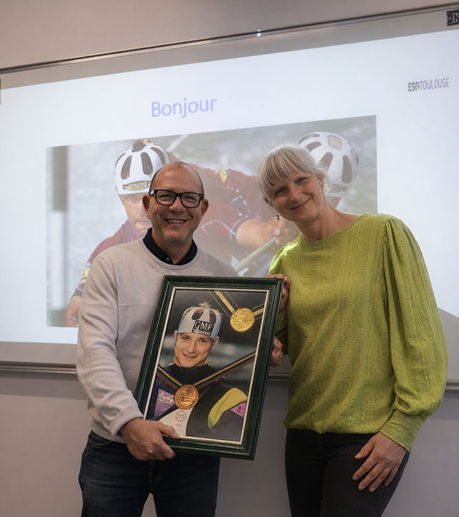 Sandra et l'intervenant pose avec le cadre photo dans lequel il y a les medailles olympiques