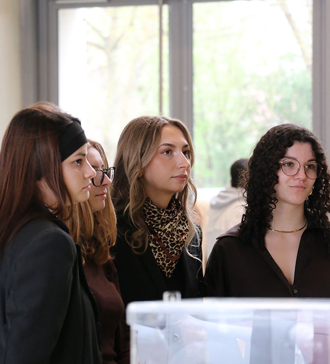 Quatre étudiants qui écoutent une personnes parler.