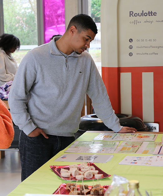 Un étudiant qui regarde les affiches posées sur la table