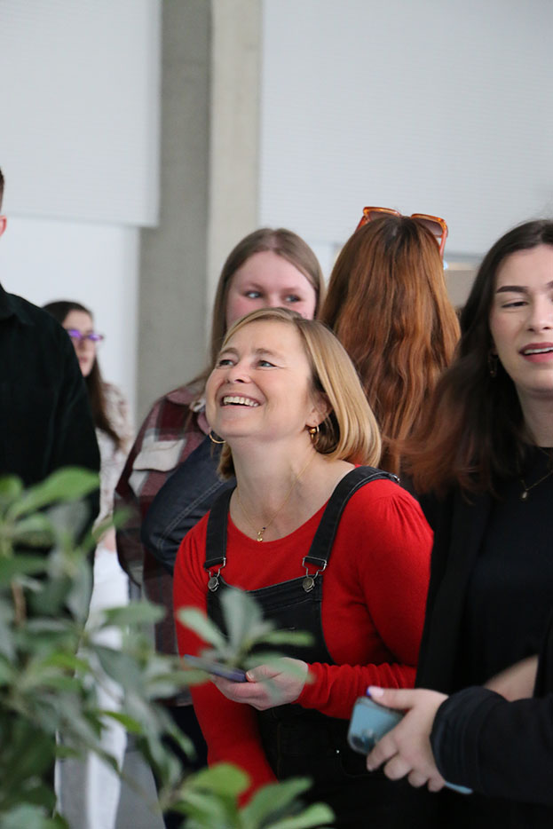 Etudiante qui sourie et qui est entouré par d'autres étudiants.