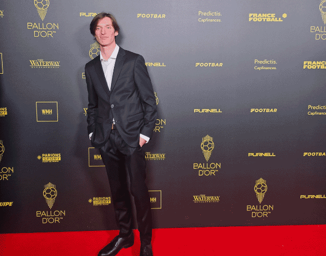 Homme en costume noir sur un tapis rouge